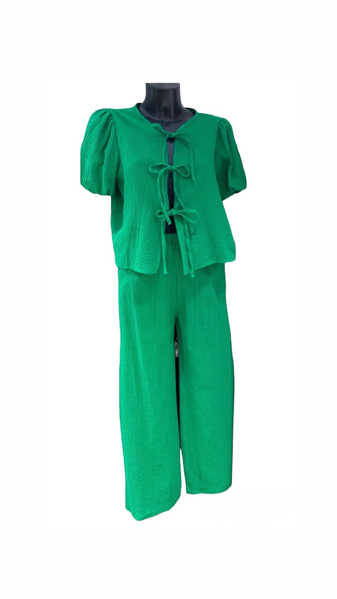 Green textured cheesecloth wide leg pant with pockets,  elasticated waistband,  Top with tie front bows,  elasticated cuff sleeve,  short puff sleeve,  peplum, 100% cotton.